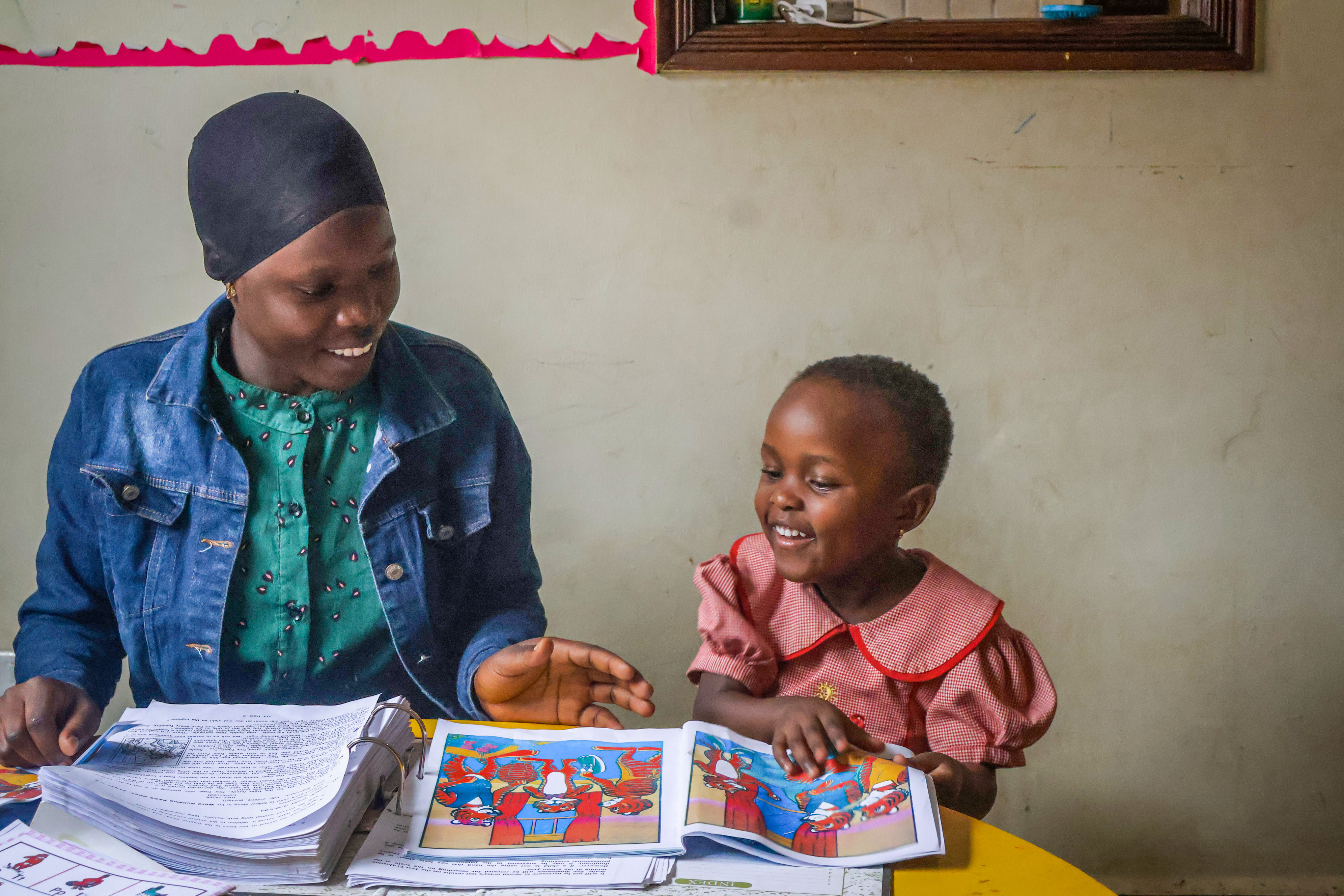 Teacher reading a picture book together with a young learner